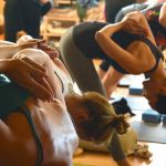 Frauen in Yoga-Position in Trainingsraum