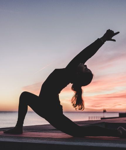 Frau in Yoga-Pose nach oben rechts deutend
